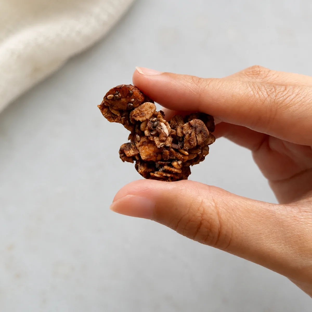 A cluster of byGrandees granola held between fingers